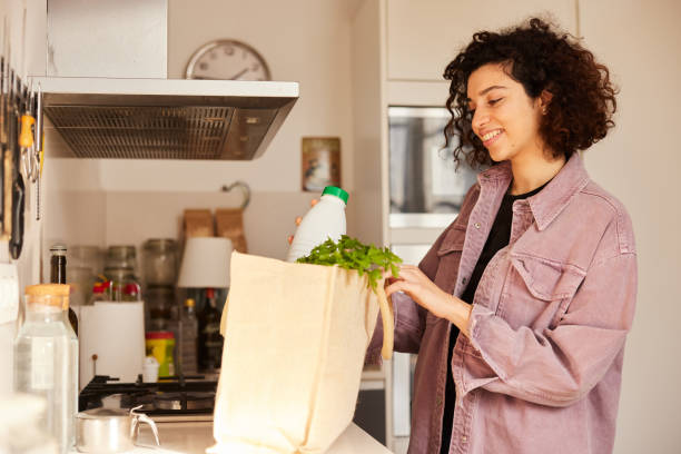 istock Pantry Stock-Up: Woman Adds Milk from Grocery Haul 1460748686