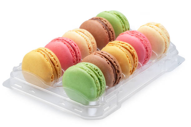 Colorful french macarons in plastic box isolated on white background.