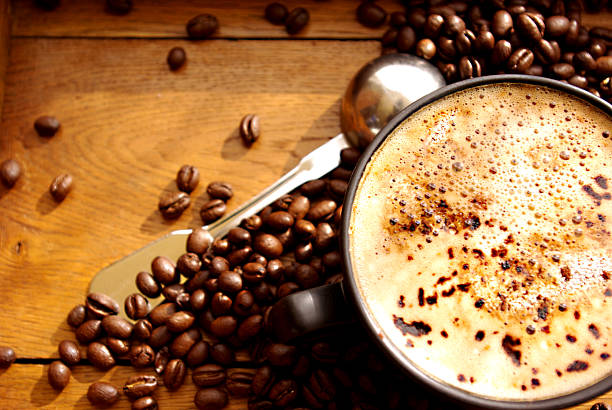 black cup of coffee and coffee beans and silver spoon 