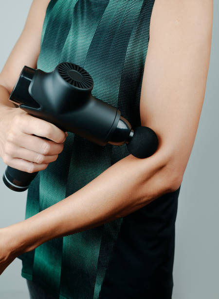 istock sportsman is using a massage gun on his arm 1460752029