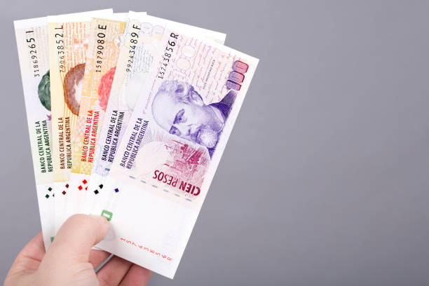 istock Old Argentine peso  in the hand on a gray background 1460752115