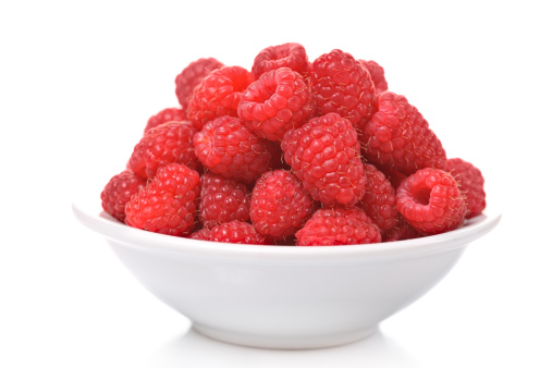 Raspberries in a bowl isolated on white background