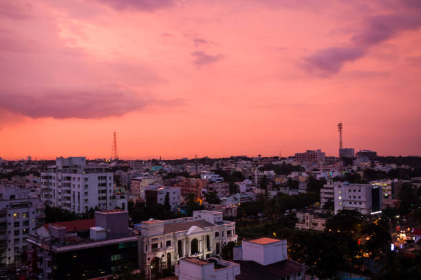 Bengaluru urban cityscape view at sunset during monsoon.View of South Bangalore skyline with clouds,pink sky,residential apartments,office buildings exterior architecture. Bangalore,Karnataka,India