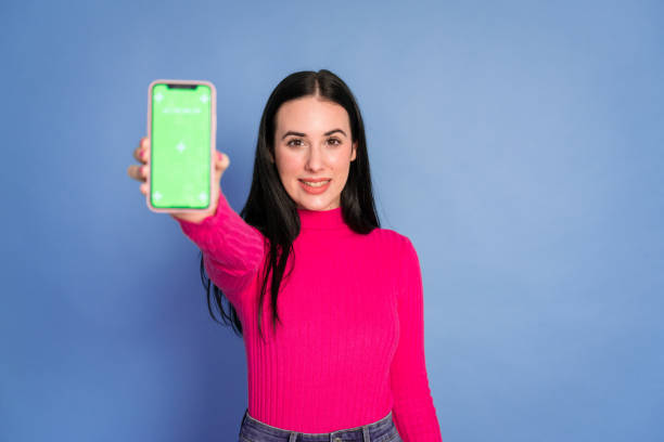 istock Smiling woman with smartphone green screen 1460761091