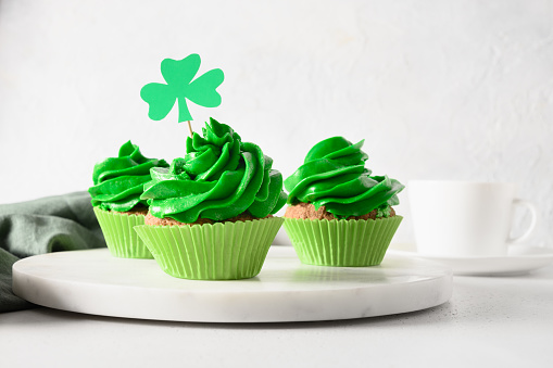 Homemade chocolate cupcake with green whipped cream on white background for St. Patrick's Day. Close up.