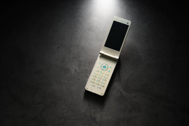 istock Old used cell phone on dark background 1460764647