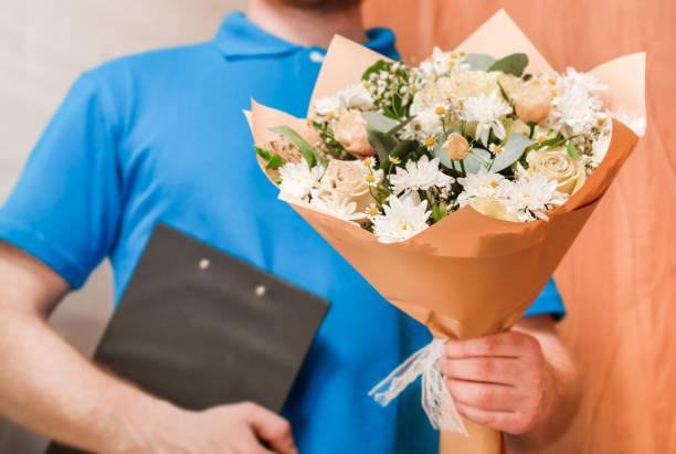 courier holds out a bouquet of flowers, home delivery of flowers