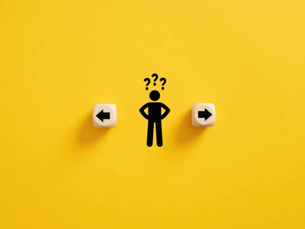 Decision making and choosing the right path. Confusion about deciding which direction to go. Stickman with question marks standing in between the wooden cubes with arrow symbols.