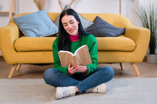 istock Cheerful woman with book at home 1460768587