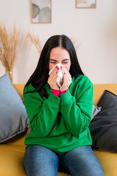 istock young woman blowing her nose and mouth 1460769456