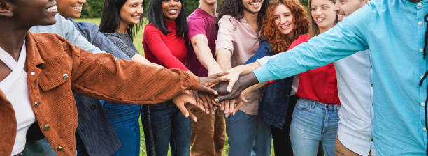 istock Young diverse team having fun stacking hands outdoor - Focus on hands 1460770094