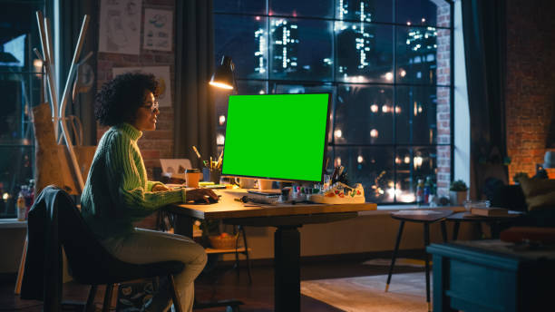 istock Diverse Professional Freelancer Working on Personal Computer with Green Screen Chromakey on Display From Home. Woman Looking at Monitor, Browsing Through the Internet, Using Desktop PC. 1460773997