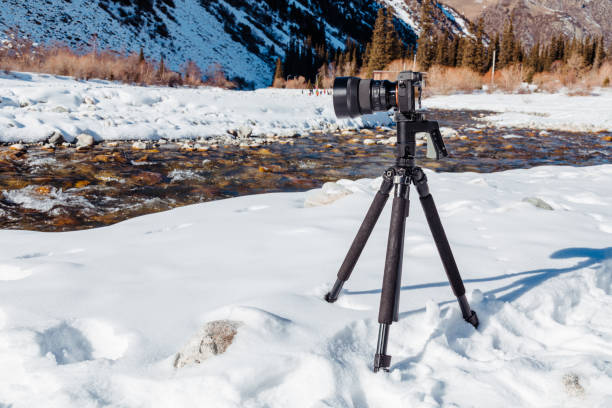 istock Digital camera on tripod taking picture of mountain river 1460774562