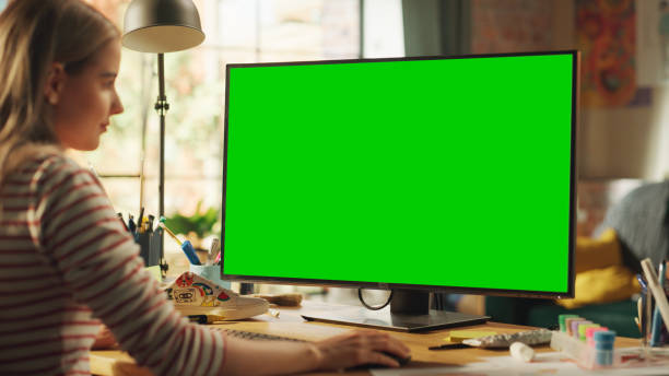 istock Blonde Female Creator Modelling on Desktop Computer with Green Screen Chroma Key on Display. Freelancer Woman Working on Her Project, Adding Final Touches Before the Deadline. 1460775158
