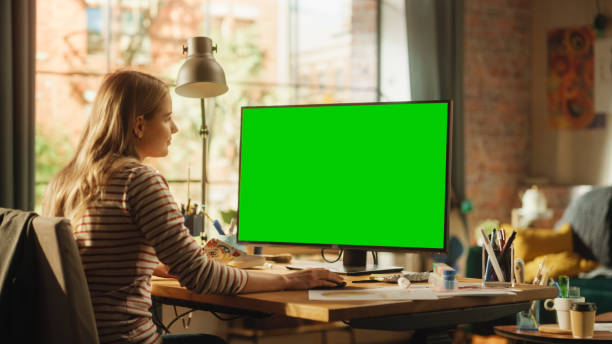 istock Focused Female Fashion Designer Using Keyboard and Modelling on Desktop Computer with Green Screen Chroma Key Monitor. Modern Successful Freelancer at Remote Work Concept. 1460775216