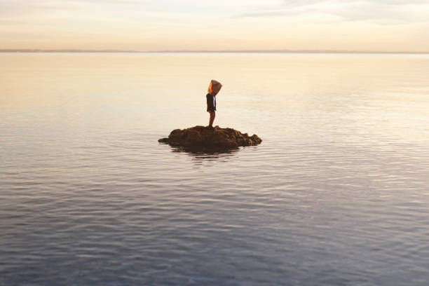 hombre con bolsa de papel en la cara no acepta su condición de náufrago en una isla, concepto abstracto - isolated despair hope assistance fotografías e imágenes de stock