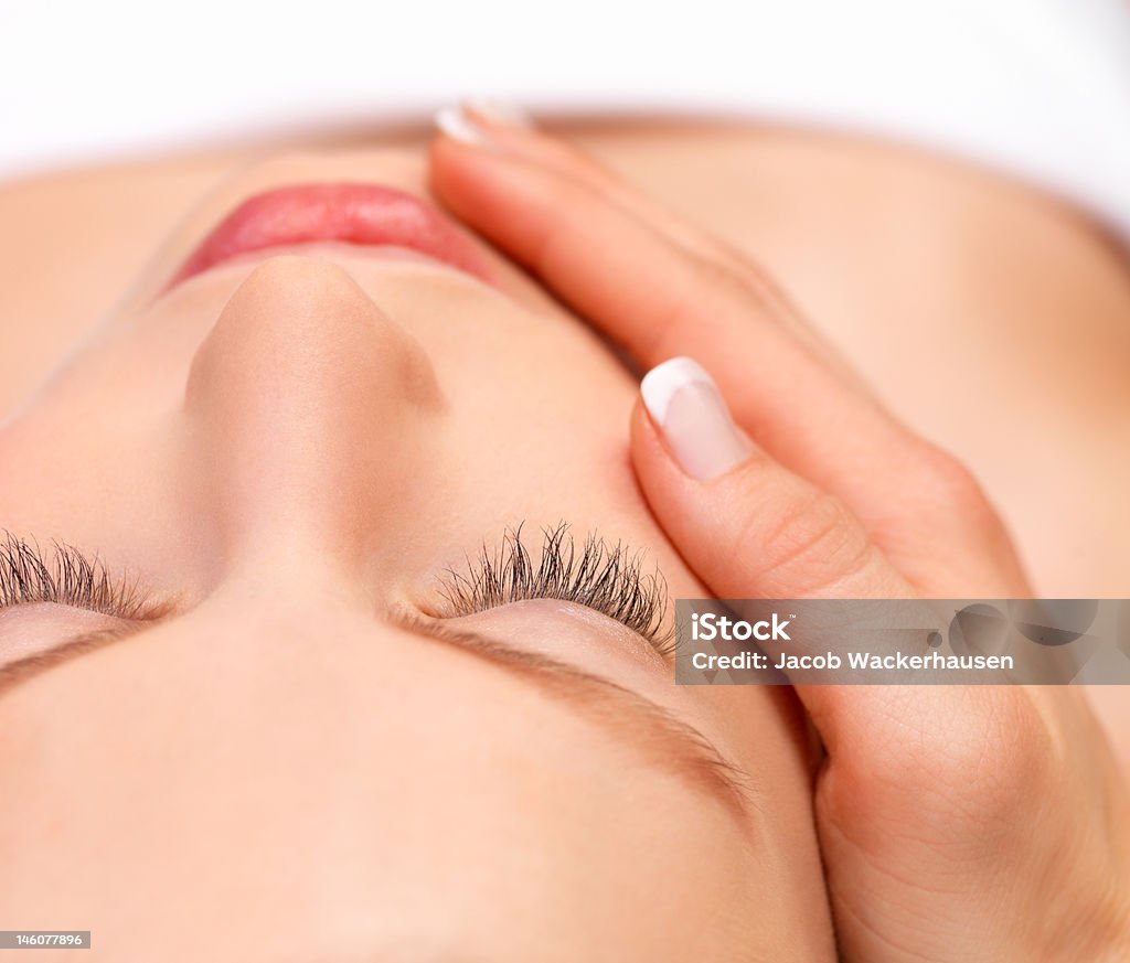 Młoda kobieta otrzymania masażu twarzy - Zbiór zdjęć royalty-free (20-24 lata)