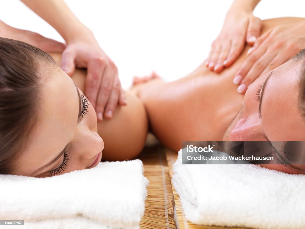 Close-up do jovem casal, recebendo massagem nos ombros em spa dia - Foto de stock de Massagear royalty-free