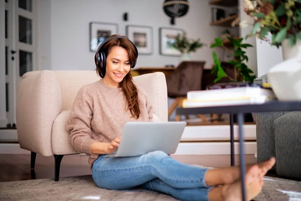 istock Attractive woman relaxing at home and using earphone and laptop 1460781038