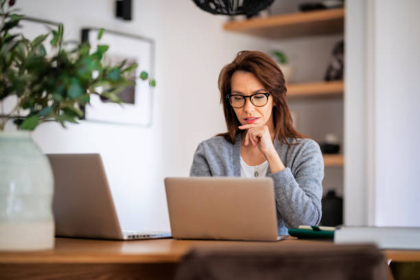 istock Attractive middle aged business woman sitting at home and using laptop for work 1460781124