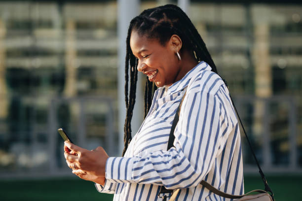 istock Smiling business woman using a smartphone while commuting in the city 1460783084