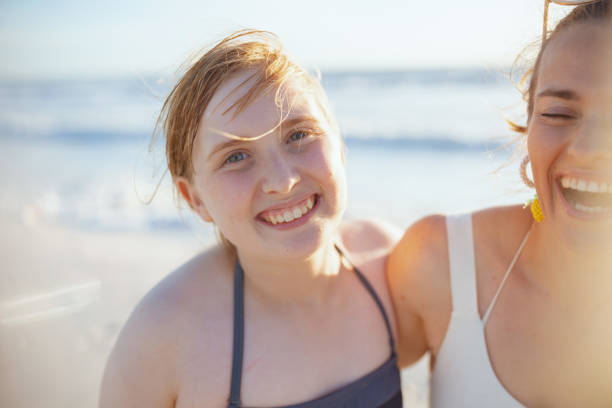 istock smiling modern mother and child at beach having fun time 1460783572