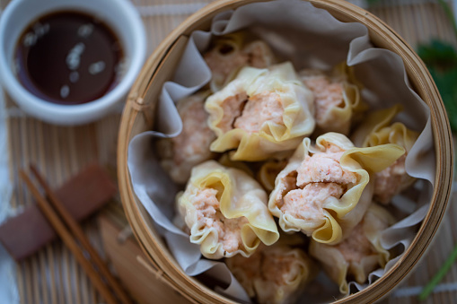 Korean Mandu Dumplings, made from flour dough and filled with seasoned chicken. Served on a plate with chili sauce