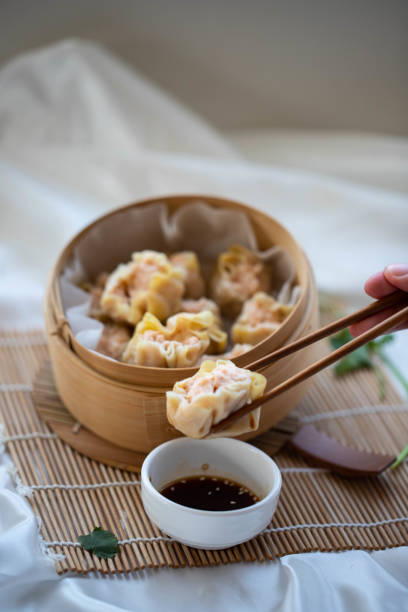 istock hand taking chinese dumpling with wooden chopsticks 1460785445