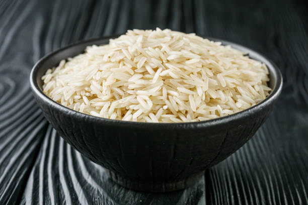 raw basmati rice on a black wooden background