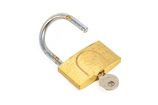 Padlock studio shot isolated on a white background. The lock has been used with some patina marks and rust.