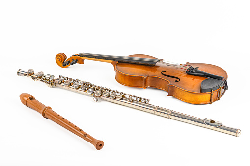 Western concert flute transverse woodwind metal musical instrument and wooden flute and a violion studio shot isolated on a white background