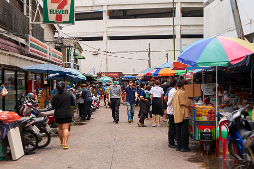 Street market in Thailand. People buy food at street stalls. Bangkok, Thailand - 09.07.2022