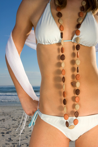 Women's Tanned body on a beach.