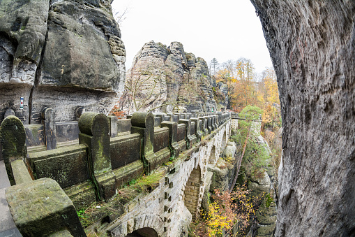 Königstein Fortress, Germany - NOV 09 2022: The Basteibrücke (Bastei Bridge) links the Bastei with the Steinschleuder and Neurathener Felsentor rocks. the wooden bridge was replaced by a sandstone bridge in 1851. It is 76.5 m long and spans the deep Mardertelle Gorge.