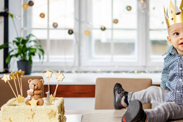 istock Little boy sitting by birthday cake 1460795126