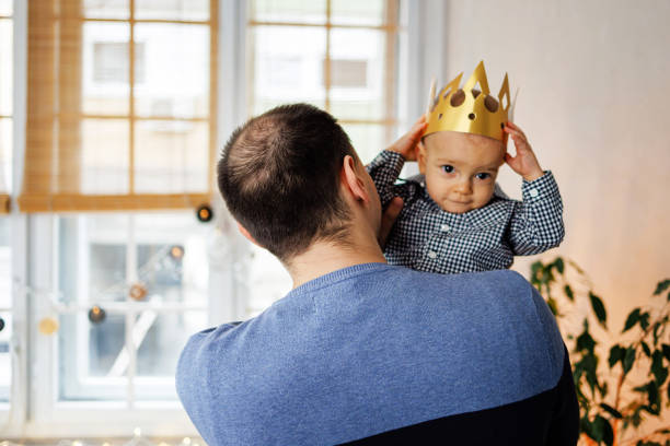 istock Father carrying son with king's crown 1460795331