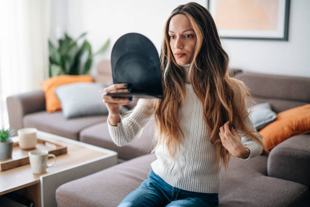 Woman adjusting her wig after hair loss due to cancer illness. Young woman adjusting her wig after hair loss due to cancer illness. wig stock pictures, royalty-free photos & images