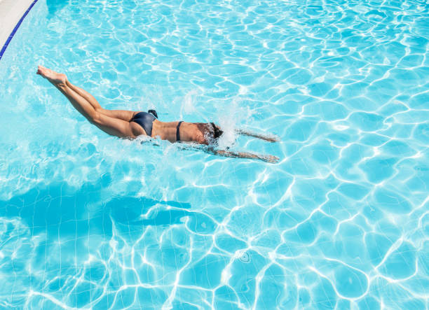 istock Woman jumping into the swimming pool. 1460799210