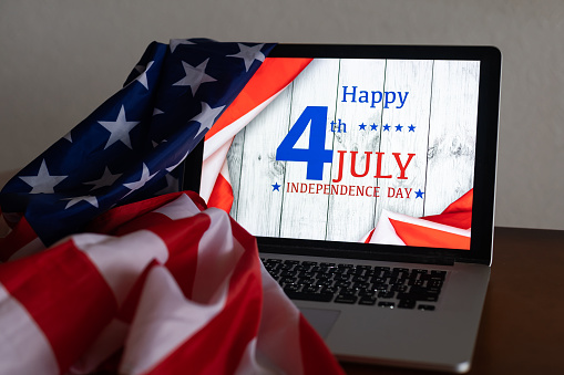 laptop with Inscription Happy independence day on usa flag