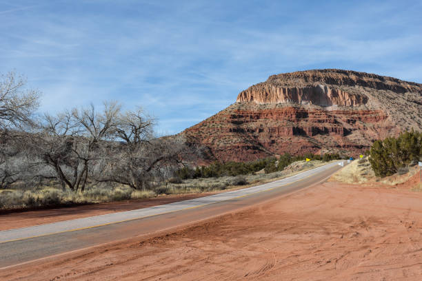 Roadway leading to Mountain range in the desert of rural New Mexico on clear day