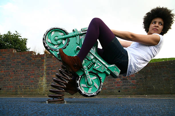 Black girl leaning back on toy motorcycle