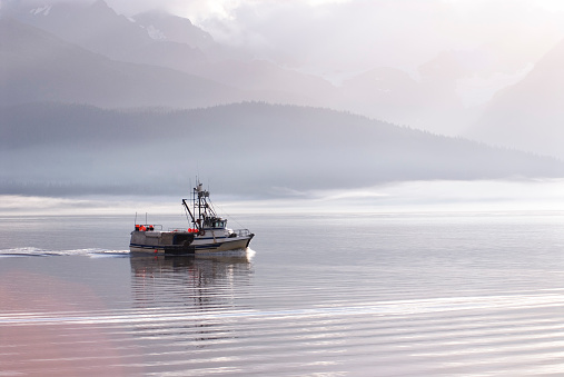 Commercial fishing boat heading out into the ocean near Seward Alaska
