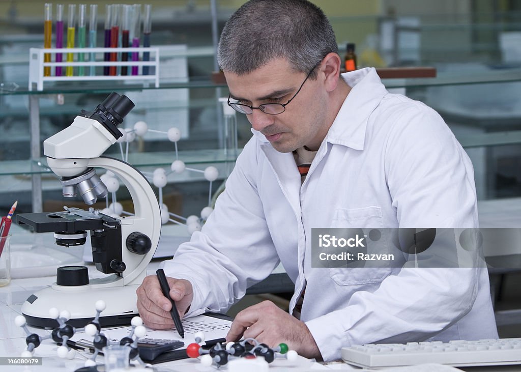 Researcher writing A researcher doing some calculation at his workplace.All the inscriptions are mine. Chemical Worker Stock Photo