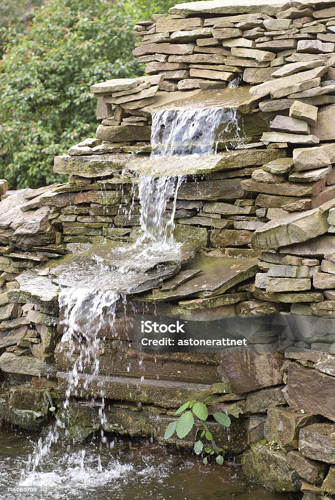 Garden waterfall Garden waterfall with a weed growing at base of it. Cracked Stock Photo