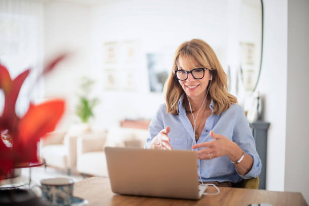 istock Attractive woman with earphone using her laptop at home 1460807883
