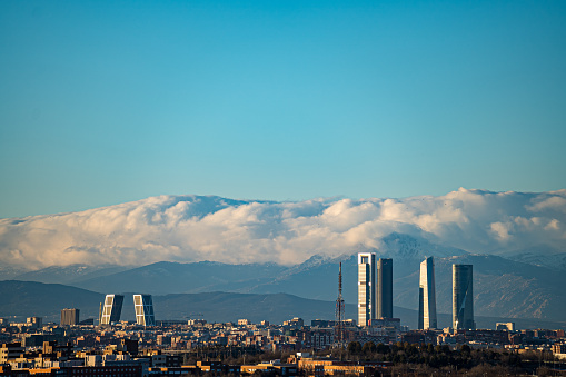 Madrid Spain. January 26, 2023. Skyline of the city of Madrid with the towers of Castellana street and the Navacerrada mountain with snow in the background.