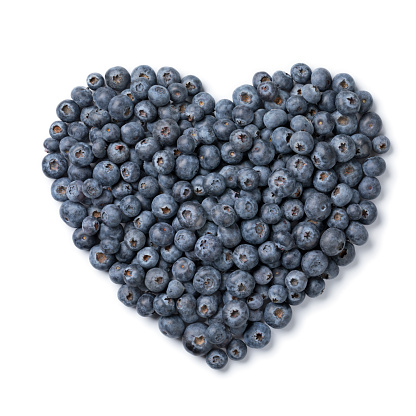 Fresh ripe raw blueberries in heart shape isolated on white background close up