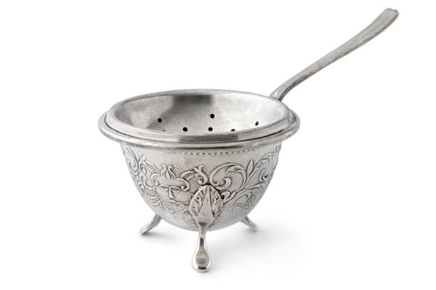 Single antique old fashion silver tea strainer and stand isolated on white background