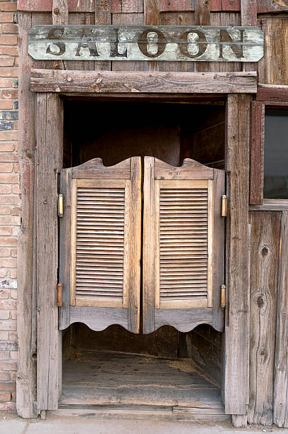 Saloon Doors with Sign Old Western Swinging Saloon Doors with a Saloon Sign Above Doors saloon photos stock pictures, royalty-free photos & images