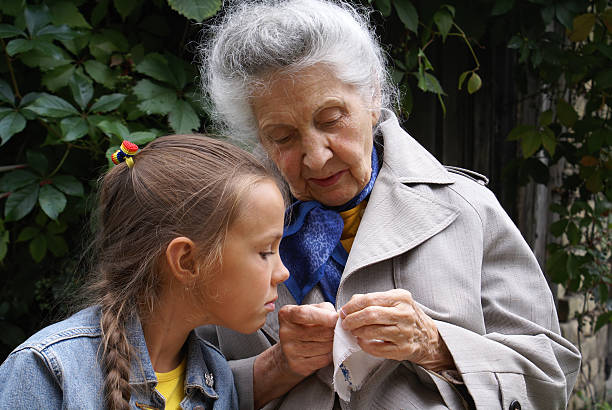 Little girl and little cute boy with grandmother together at the garden. Having fun, hugging and smiling.